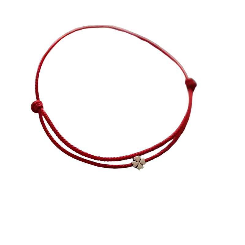 Red bracelet with a small gold charm on a white surface