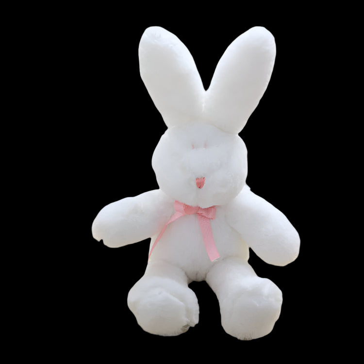 White plush bunny with a pink bow on a light surface