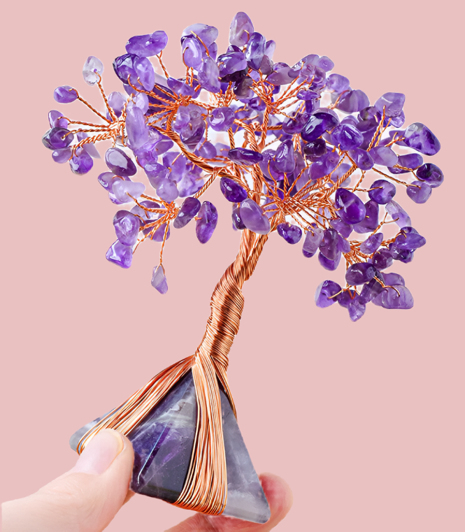 Crystal tree with purple stones and copper wire on a plain background