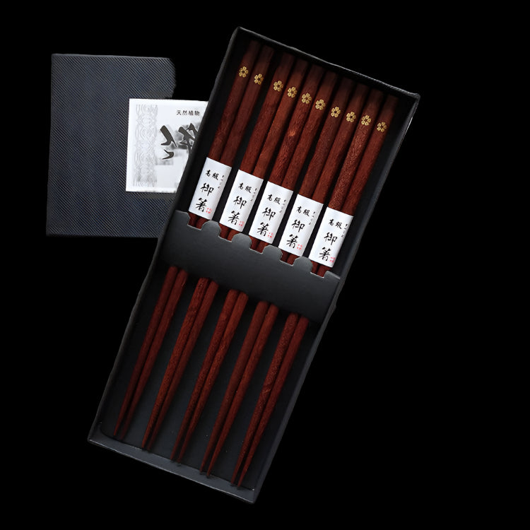 Set of wooden chopsticks with name labels in a black box on an old text background