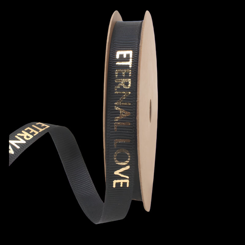 Black ribbon with 'Eternal Love' text on a cardboard spool against a white background