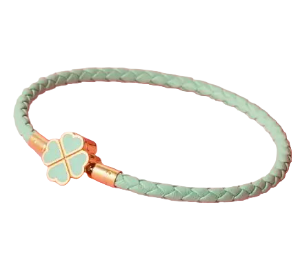 Mint green braided bracelet with a four-leaf clover charm on a pink background