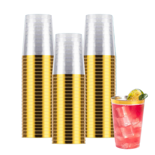 Set of gold and silver plastic cups with a cocktail in the foreground on a white background