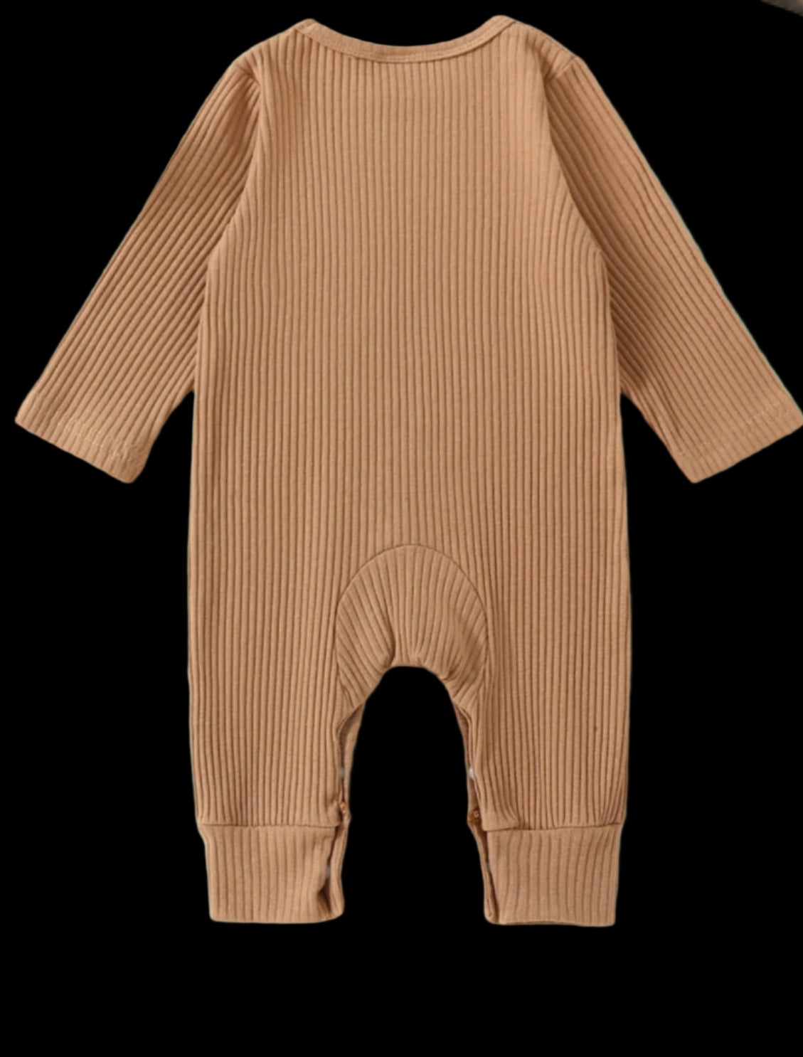 Brown ribbed baby onesie on a beige background with toys and plants.