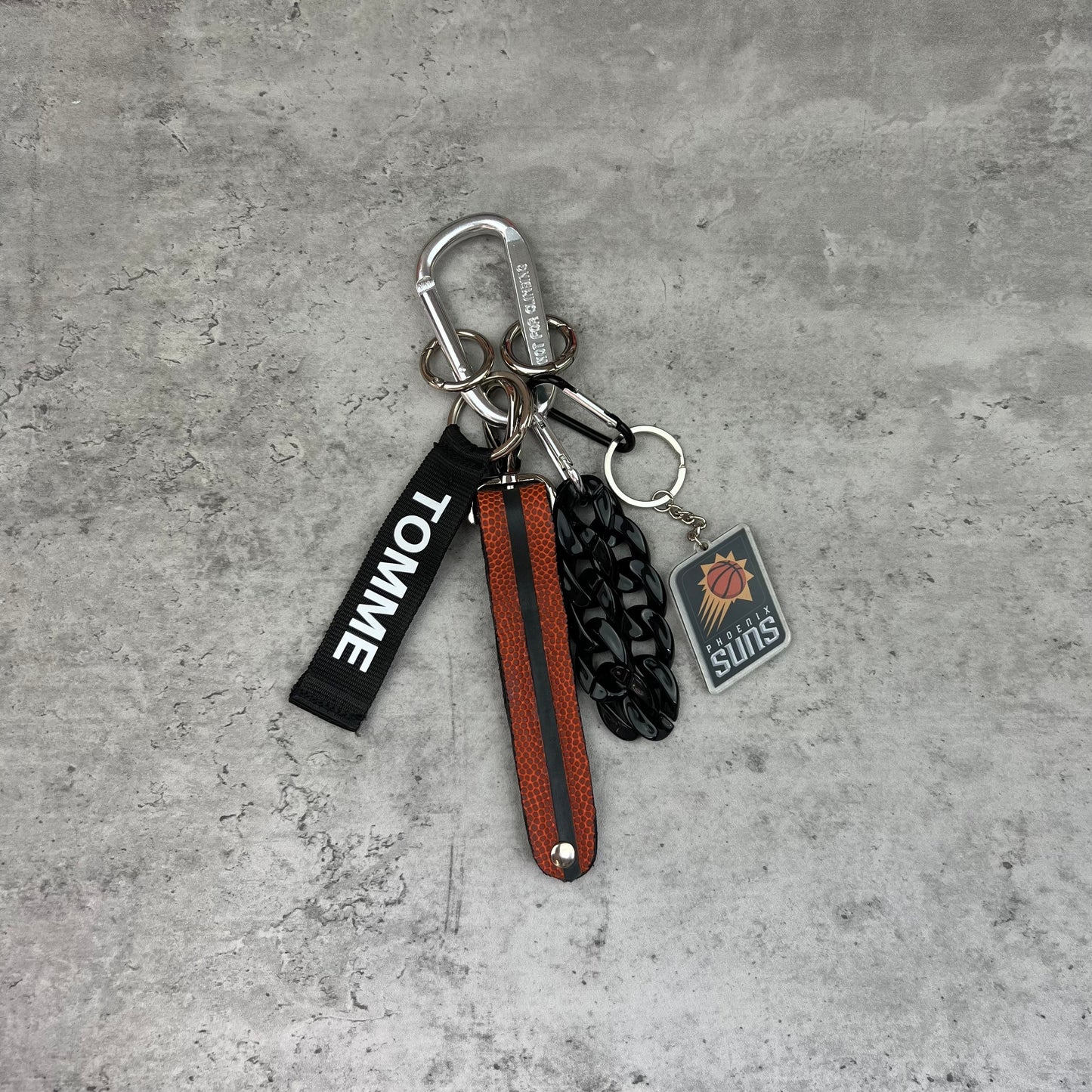 Keychain with multiple charms on a concrete surface