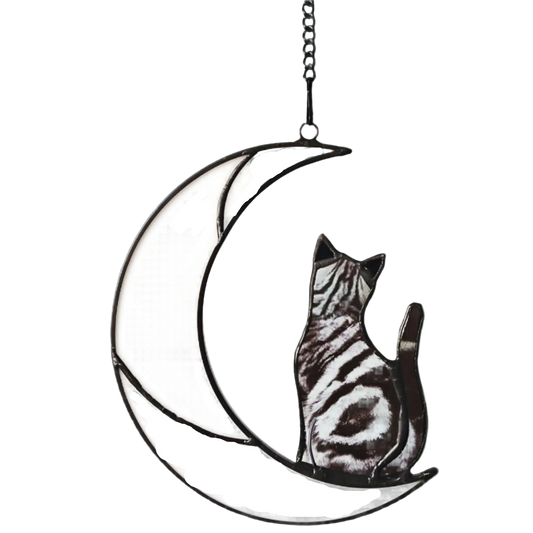 Decorative metal wall art of a cat sitting on a crescent moon