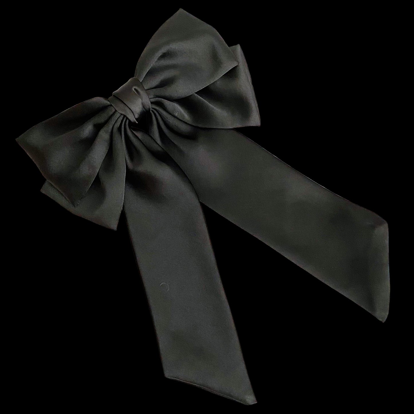 Black satin bow on a light wooden surface