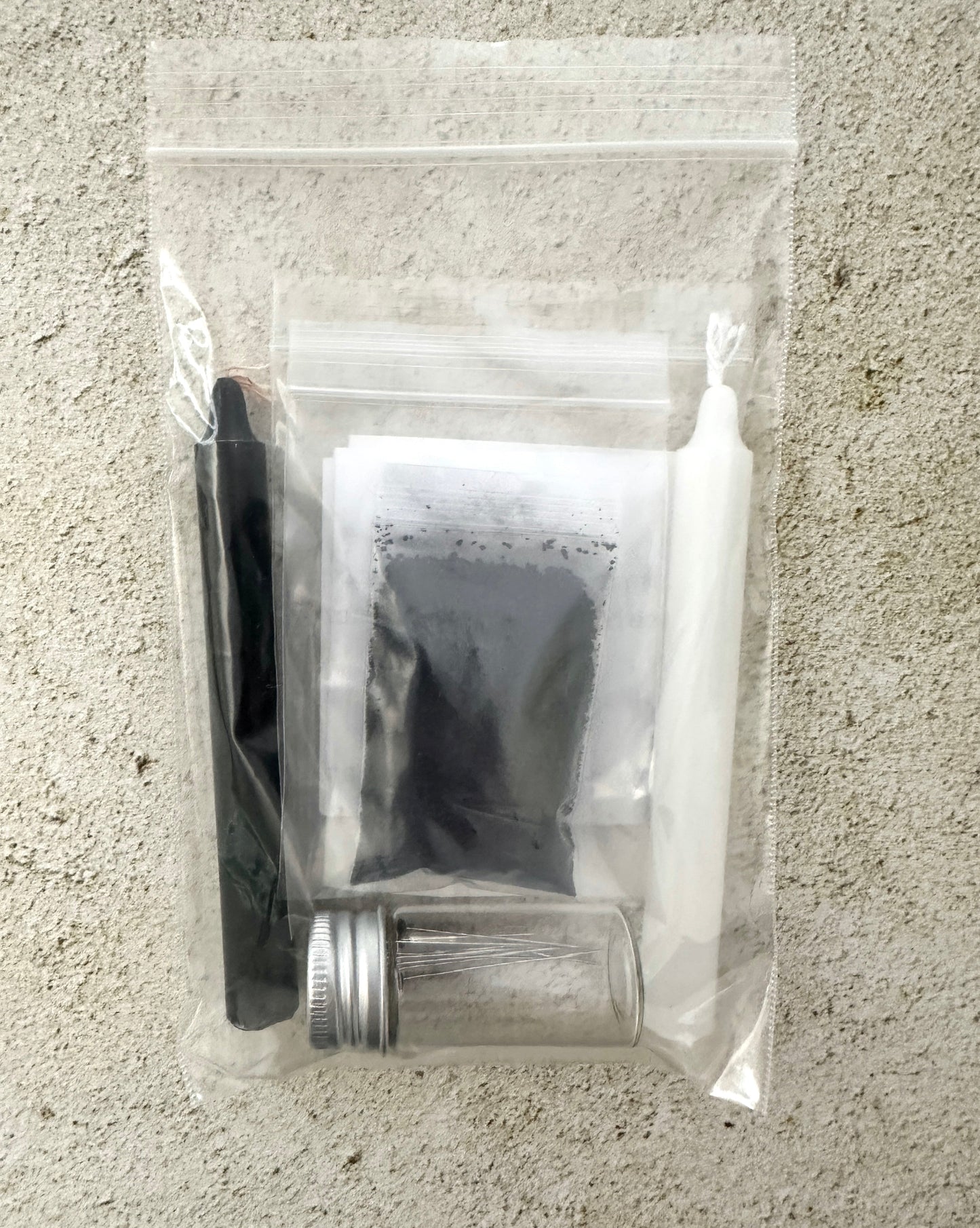 Clear plastic bag with grooming items including a brush, scissors, and a small container on a textured surface.