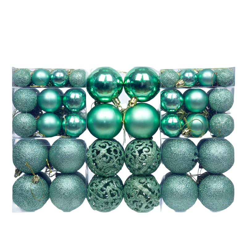 Assorted green Christmas ornaments in a clear box on a white background