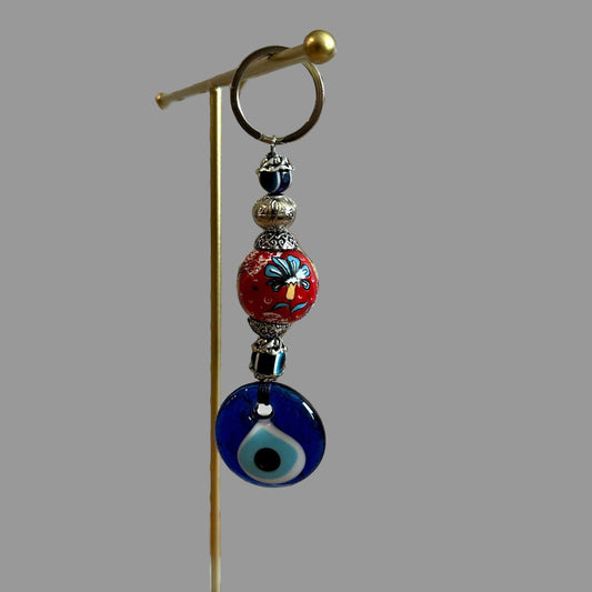 Decorative keychain with beads on a stand against a geometric patterned wall.