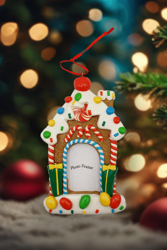 Decorative gingerbread house photo frame ornament with a blurred Christmas tree background
