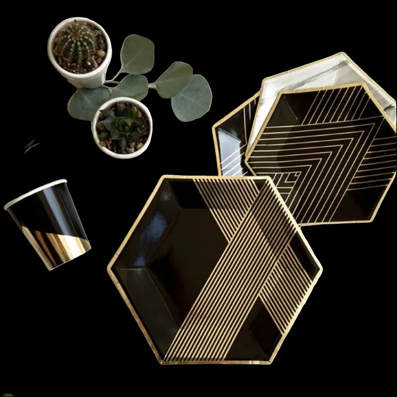 Black and gold geometric plates on a white surface with decorative elements.