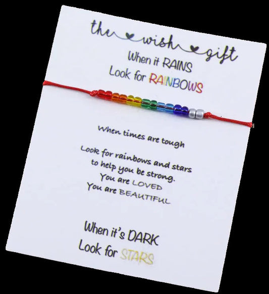 Colorful bracelet on a card with motivational text on a wooden surface