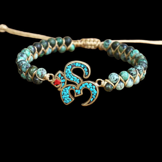 Bracelet with turquoise beads and gold accents on a wooden surface