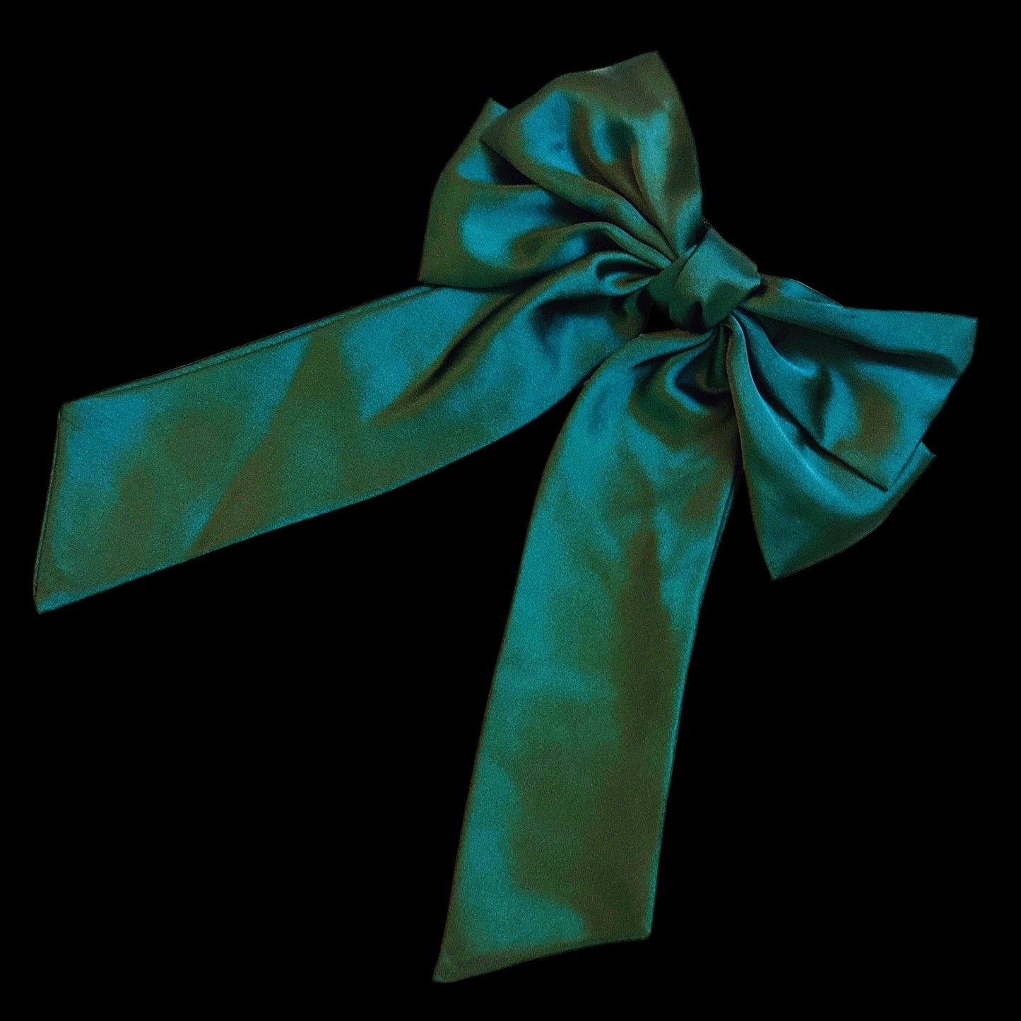 Green satin bow on a light gray background
