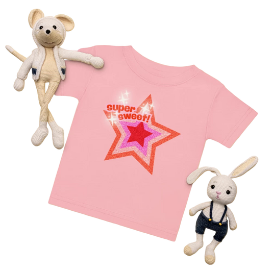 Pink t-shirt with red star design and text, surrounded by two plush toys on a yellow background