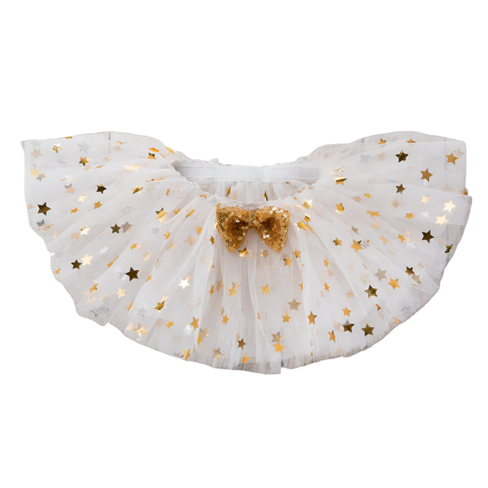 White tulle skirt with gold stars and a bow on a wooden surface