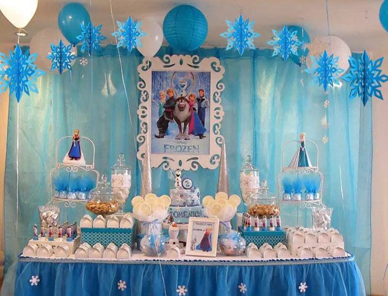 Frozen-themed dessert table with decorations and balloons