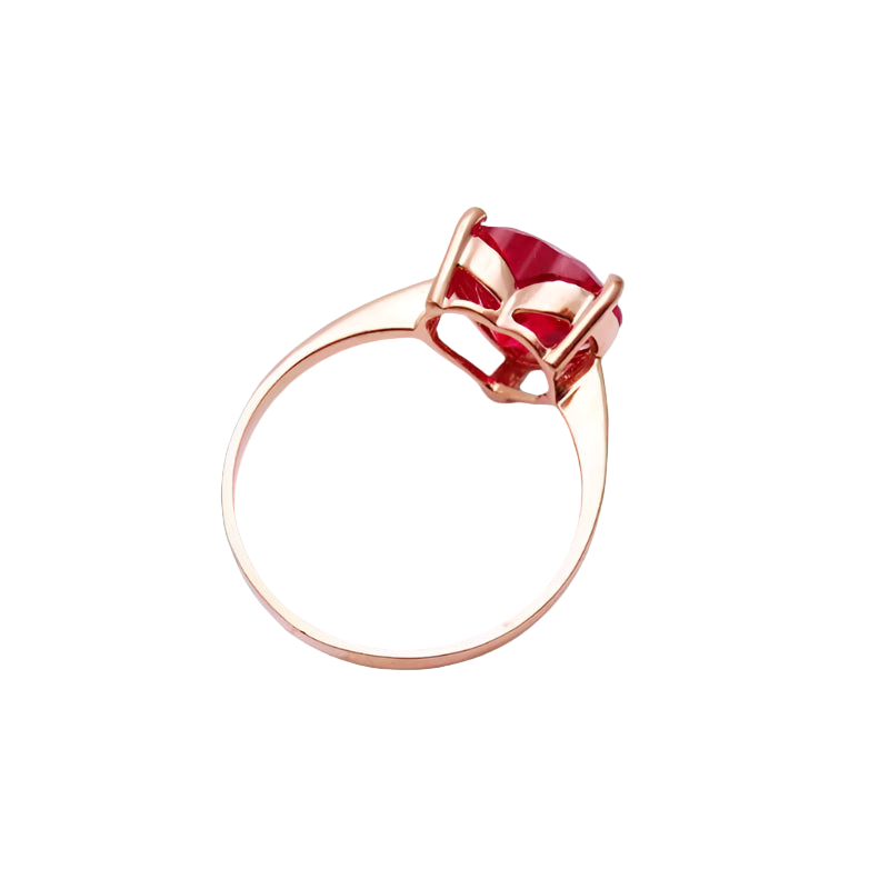 Gold ring with a red gemstone on a light gray background