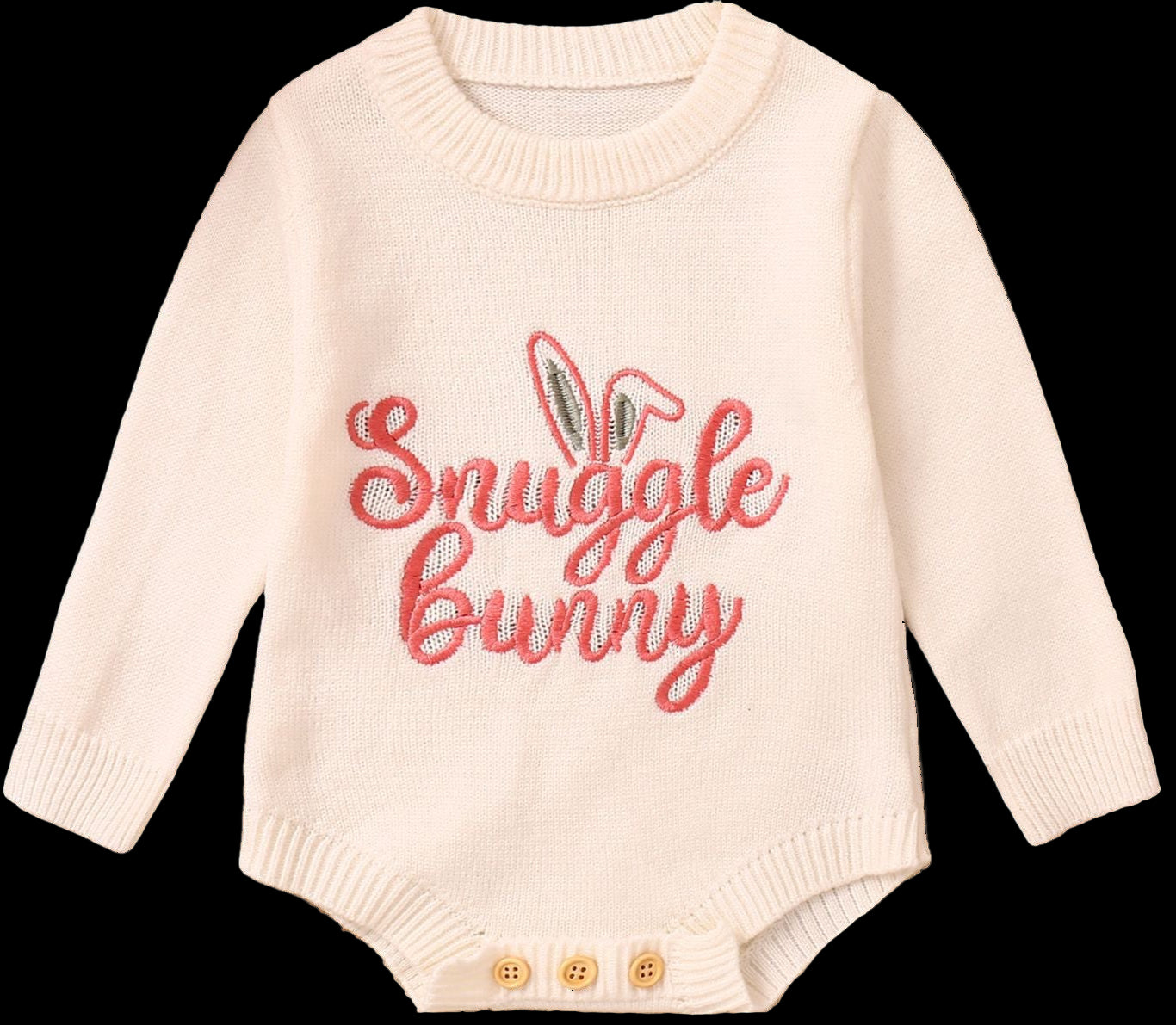 Baby sweater with 'Snuggle bunny' text on a wooden surface with decorative items.