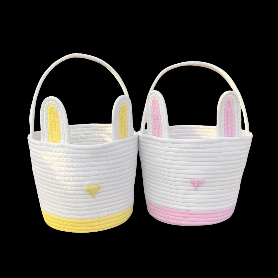 Two woven baskets with bunny ears and hearts on a stone surface.
