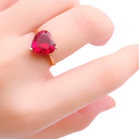 Hand wearing a ring with a red gemstone on a white background