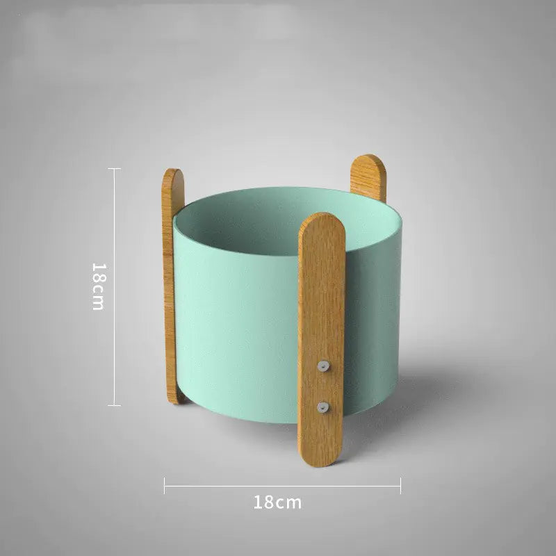 Green cylindrical container with wooden handles on a gray background