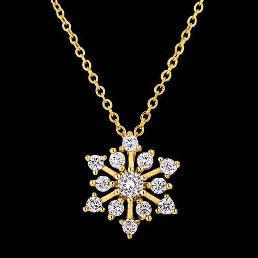Gold snowflake pendant necklace on a white background