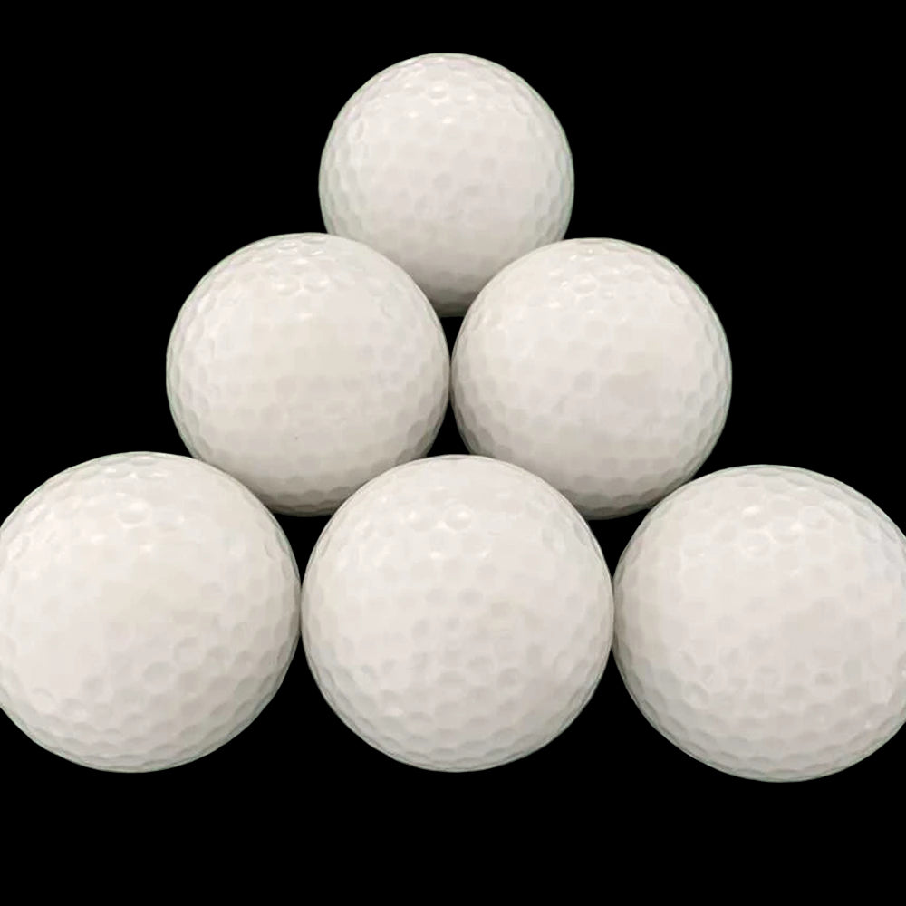 Six white golf balls on a green grass background