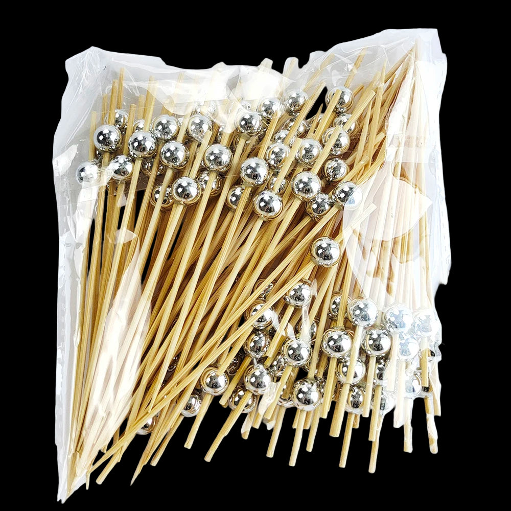 Packaged toothpicks with silver ball ends on a white background