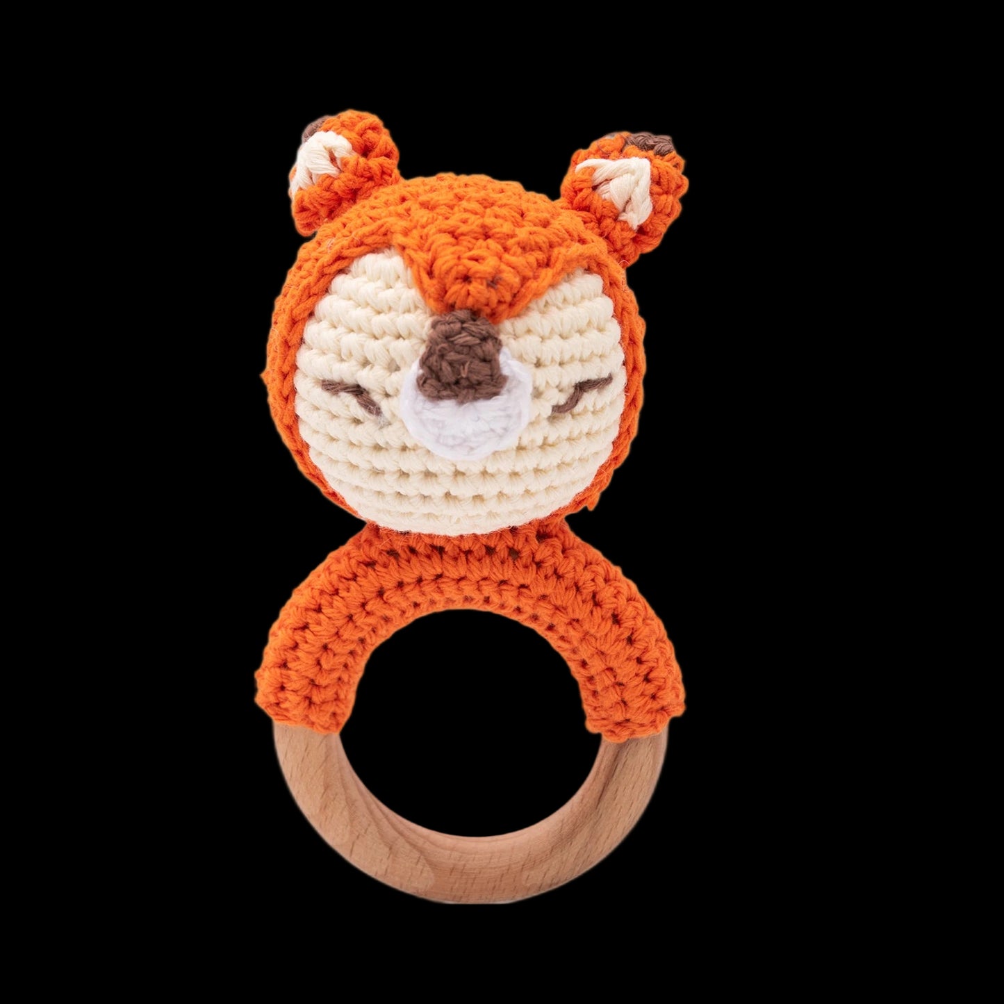 Crocheted fox rattle with wooden ring on a white background
