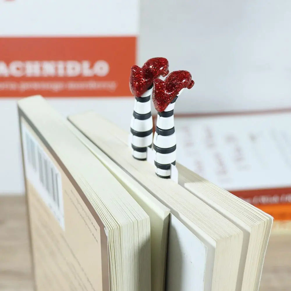 Decorative bookends with striped legs and red tops on a stack of books.