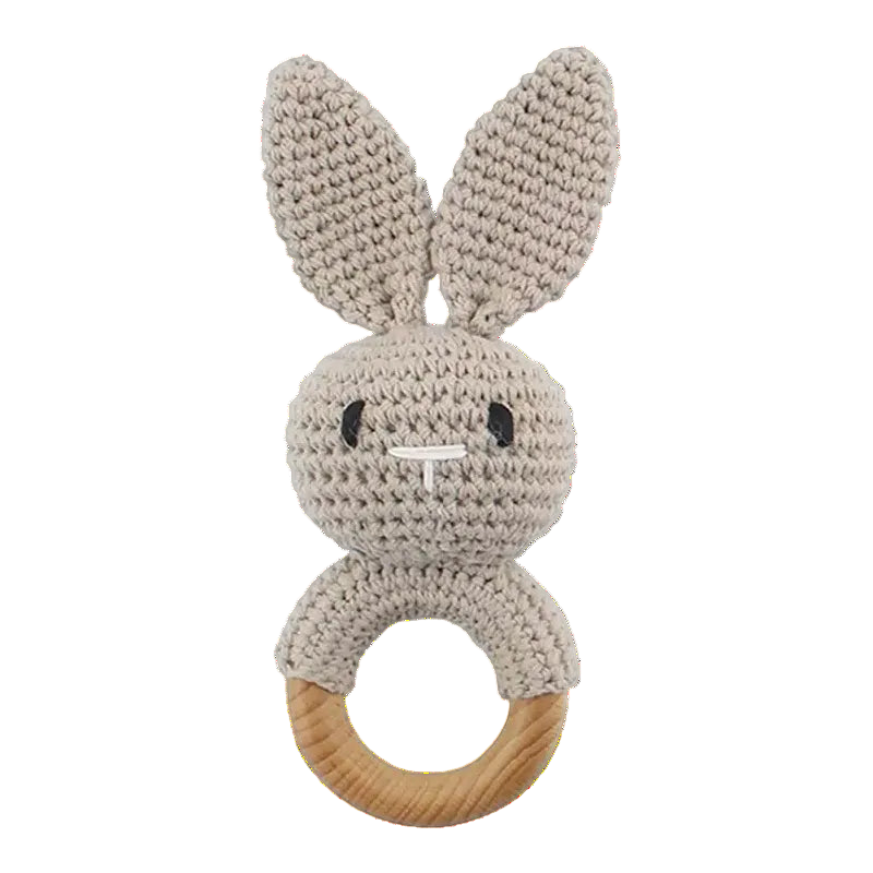 Knitted bunny rattle with wooden ring on a white background