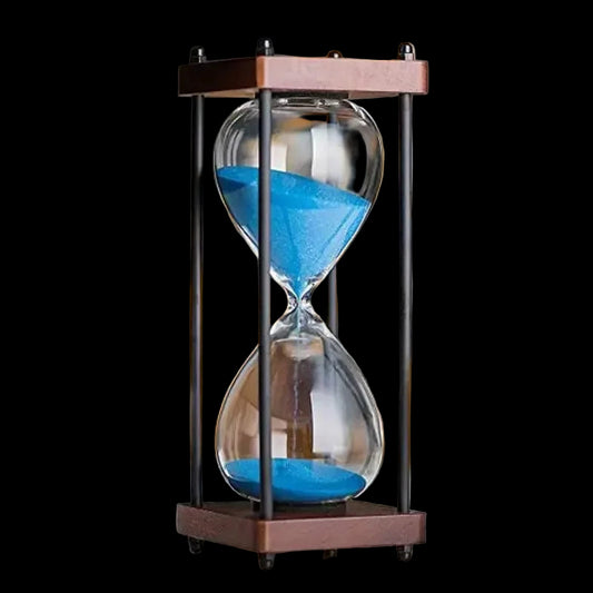 Hourglass with blue sand on a blurred background