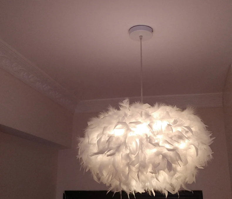 White feathered chandelier hanging from a ceiling in a room.