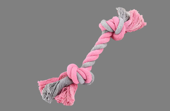 Pink and gray knotted rope toy on a book with 'L'AITA' branding.