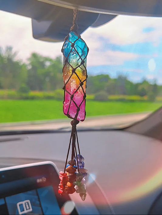 Colorful crystal car hanging inside a car with a blurred outdoor background