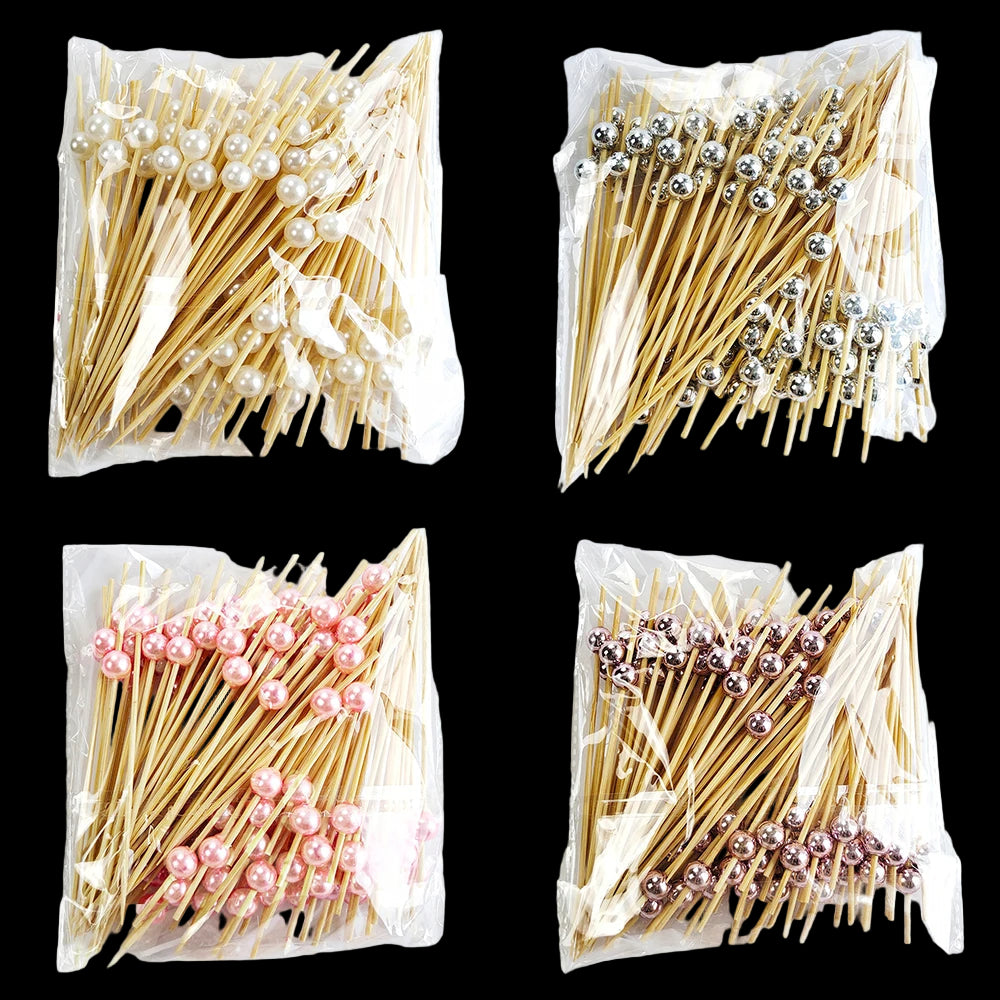 Four packages of decorative toothpicks with different colored beads on a white background