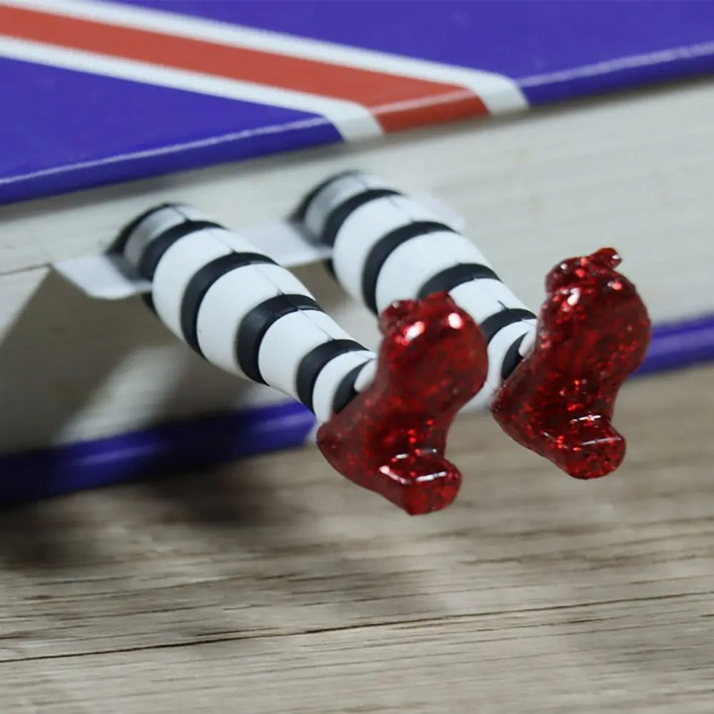 Close-up of a toy figure with red and black striped legs on a wooden surface.