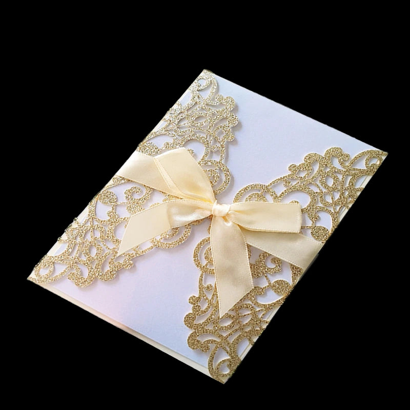 Decorative card with gold lace and a beige bow on a textured surface.