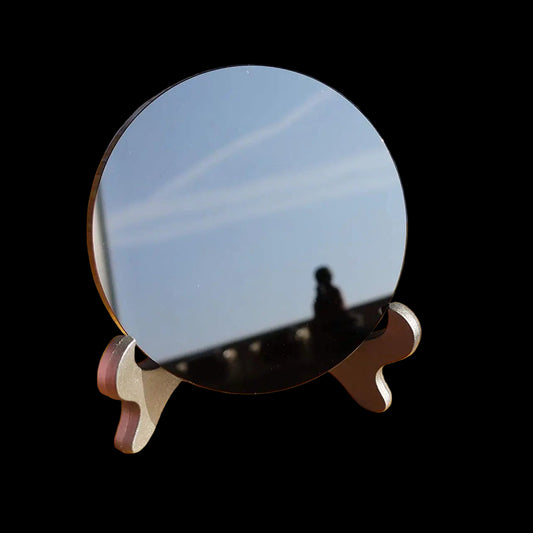 Round mirror on a wooden stand with a blurred background