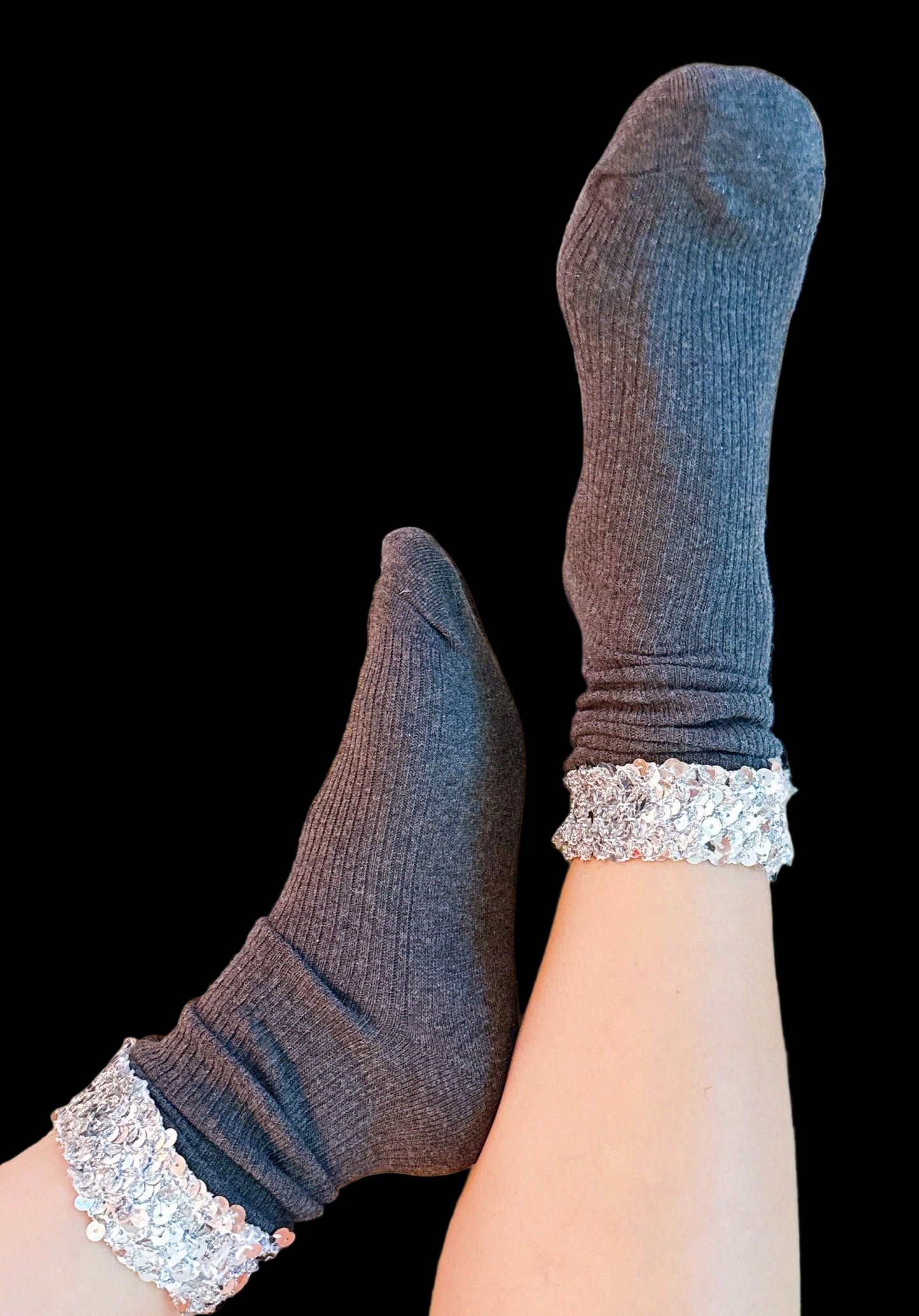 Gray socks with glitter cuffs on a patterned rug
