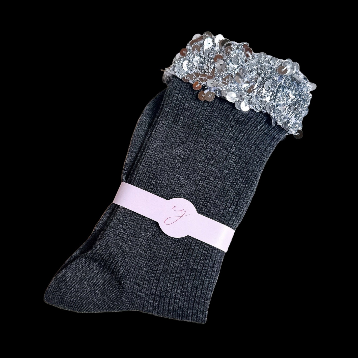 Dark gray socks with a silver sequin top and pink band on a light gray background