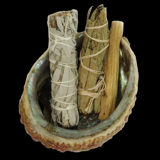 Three smudge sticks in a ceramic holder on a white background
