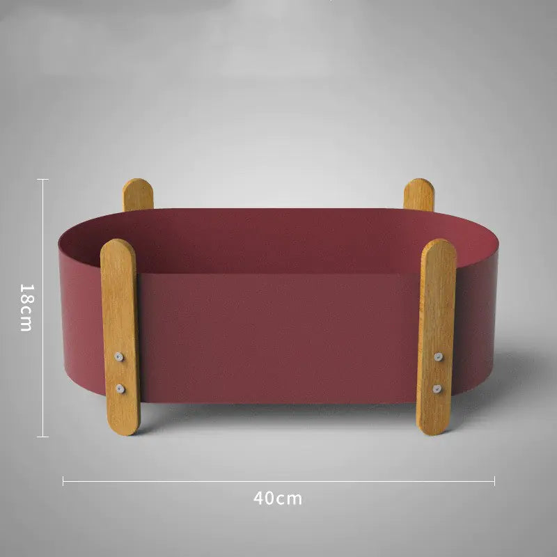 Red pet bed with wooden sides and dimensions on a gray background