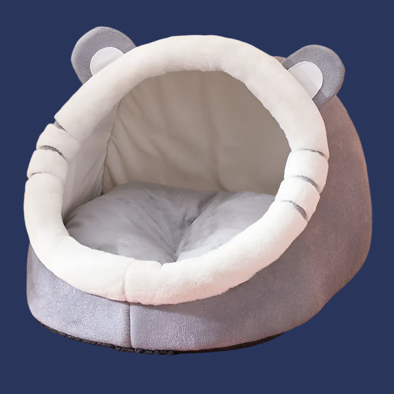 Gray pet bed with bear ears on a patterned surface