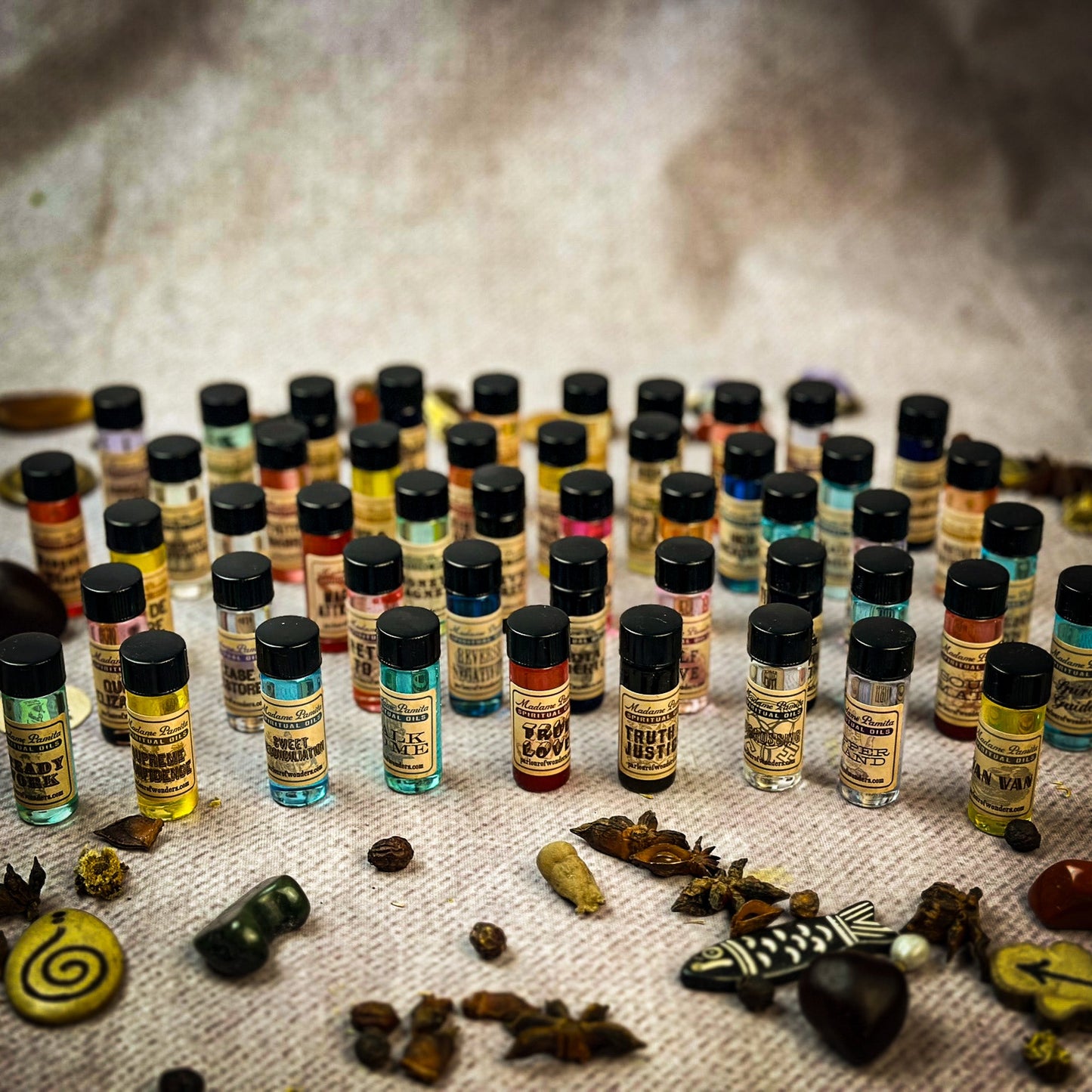 Collection of small bottles with colorful labels on a textured surface
