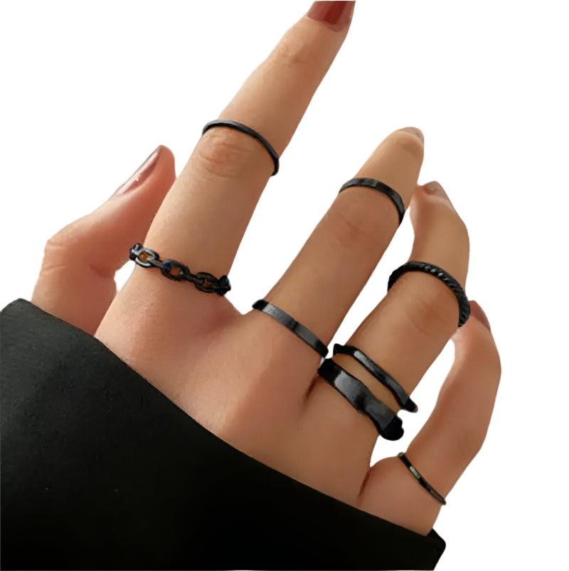 Hand wearing multiple black rings on a neutral background