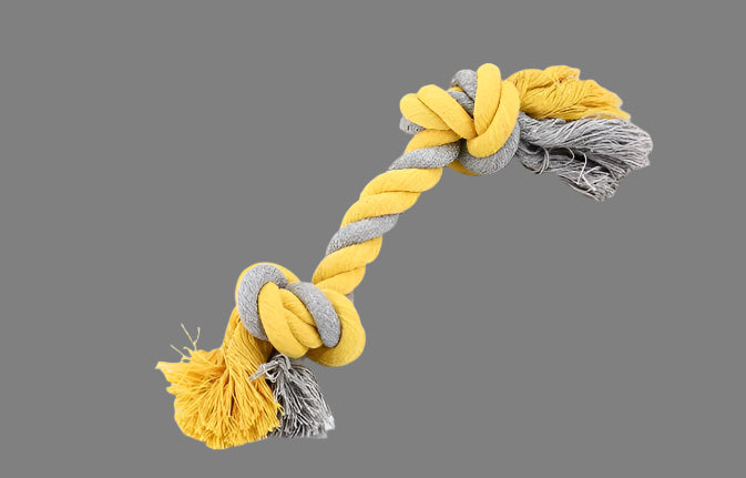 Yellow and gray knotted rope toy on a book