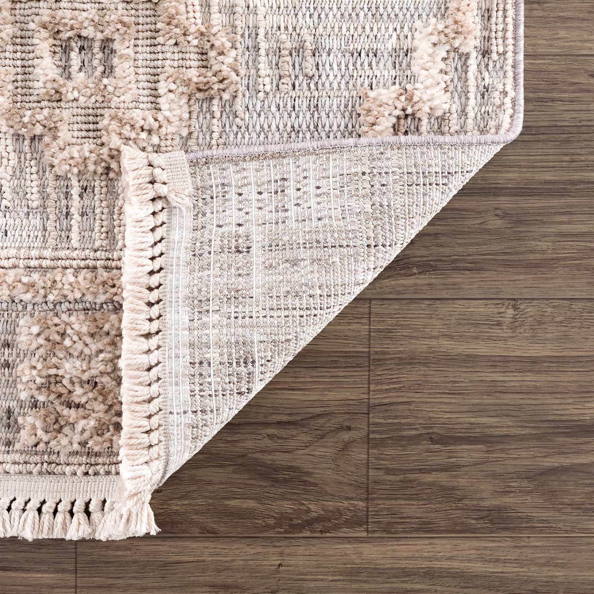 Textured area rug with tassels on a wooden floor